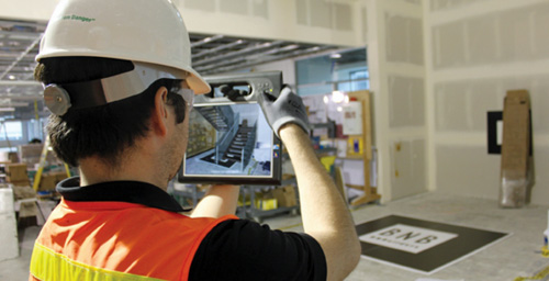 Worker using an electronic to monitor interior construction